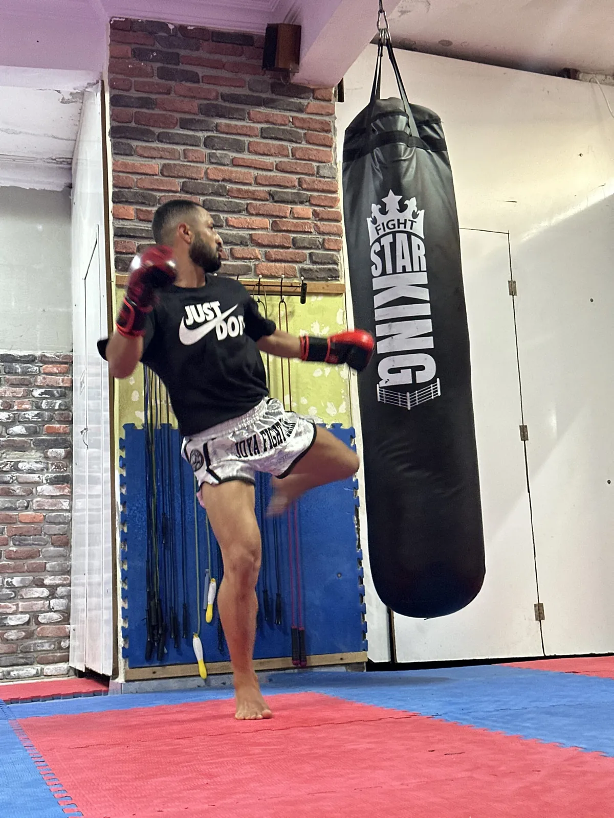 Ali Savaskan training a knee strike on a heavy bag