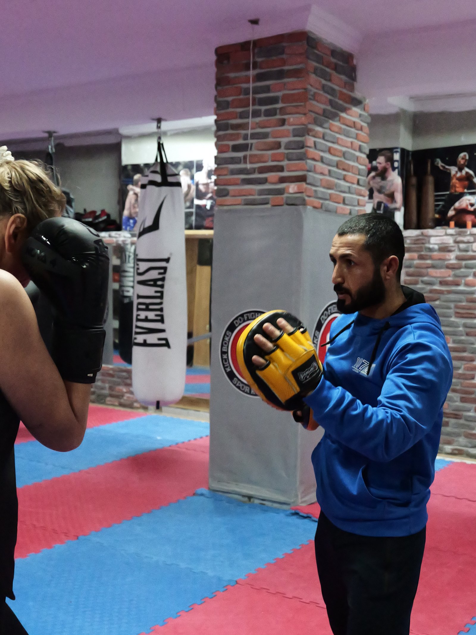 Ali holding focus mitts for a client during a striking session in Alanya