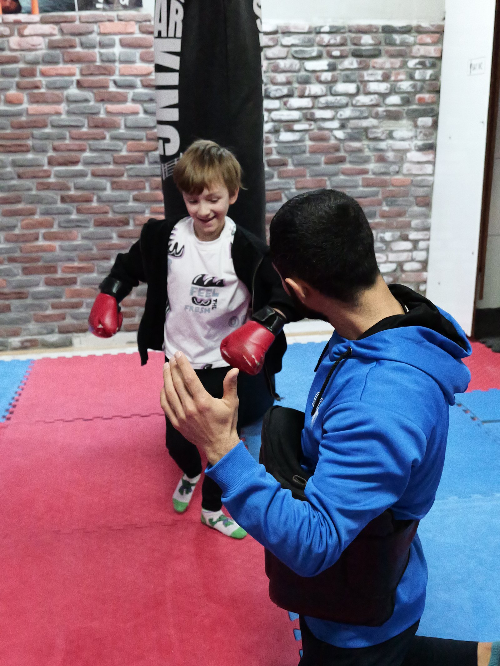 Young student in gloves training with Ali in the Alanya gym