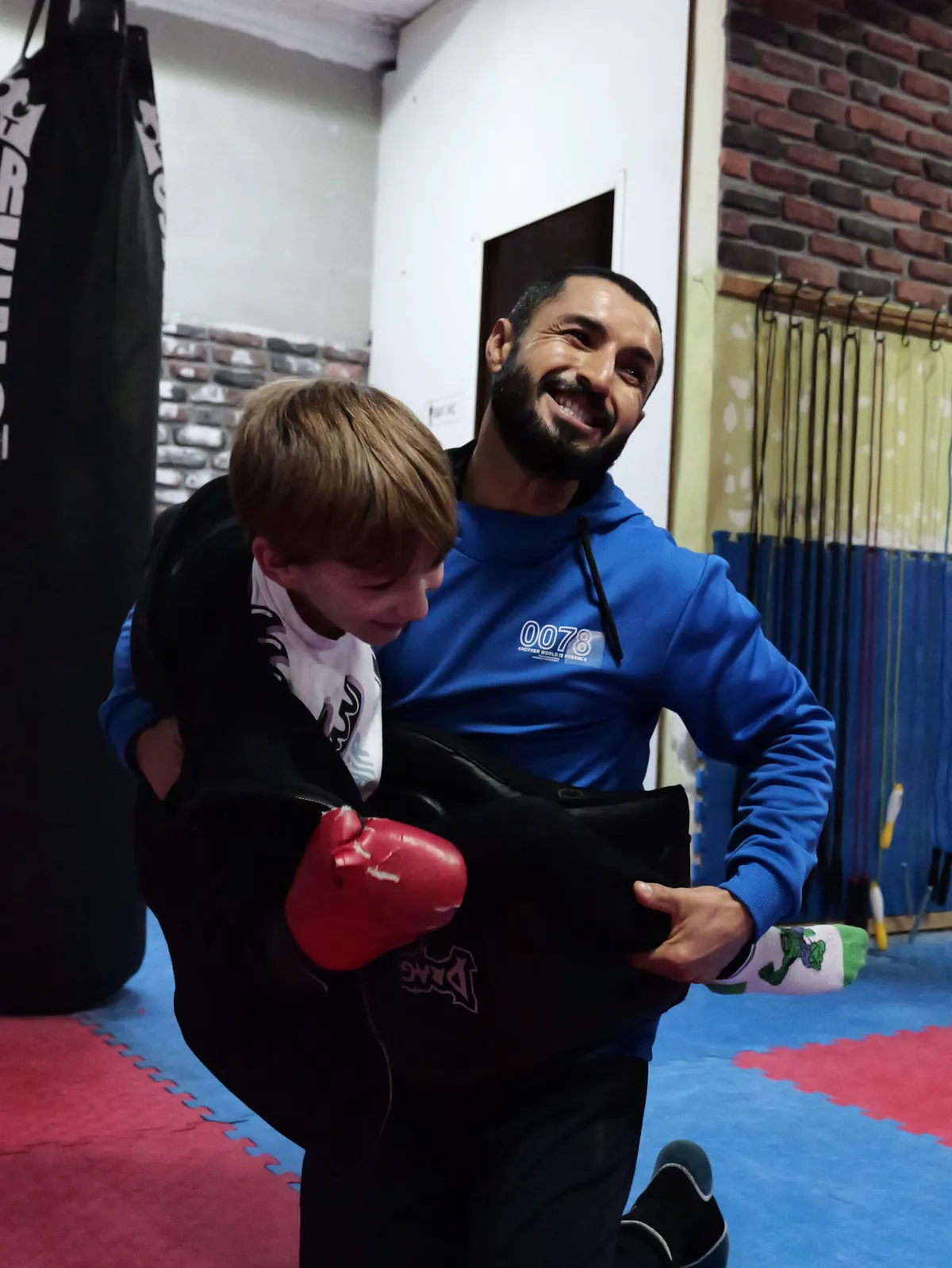 Coach Ali holding a kick shield for a young student